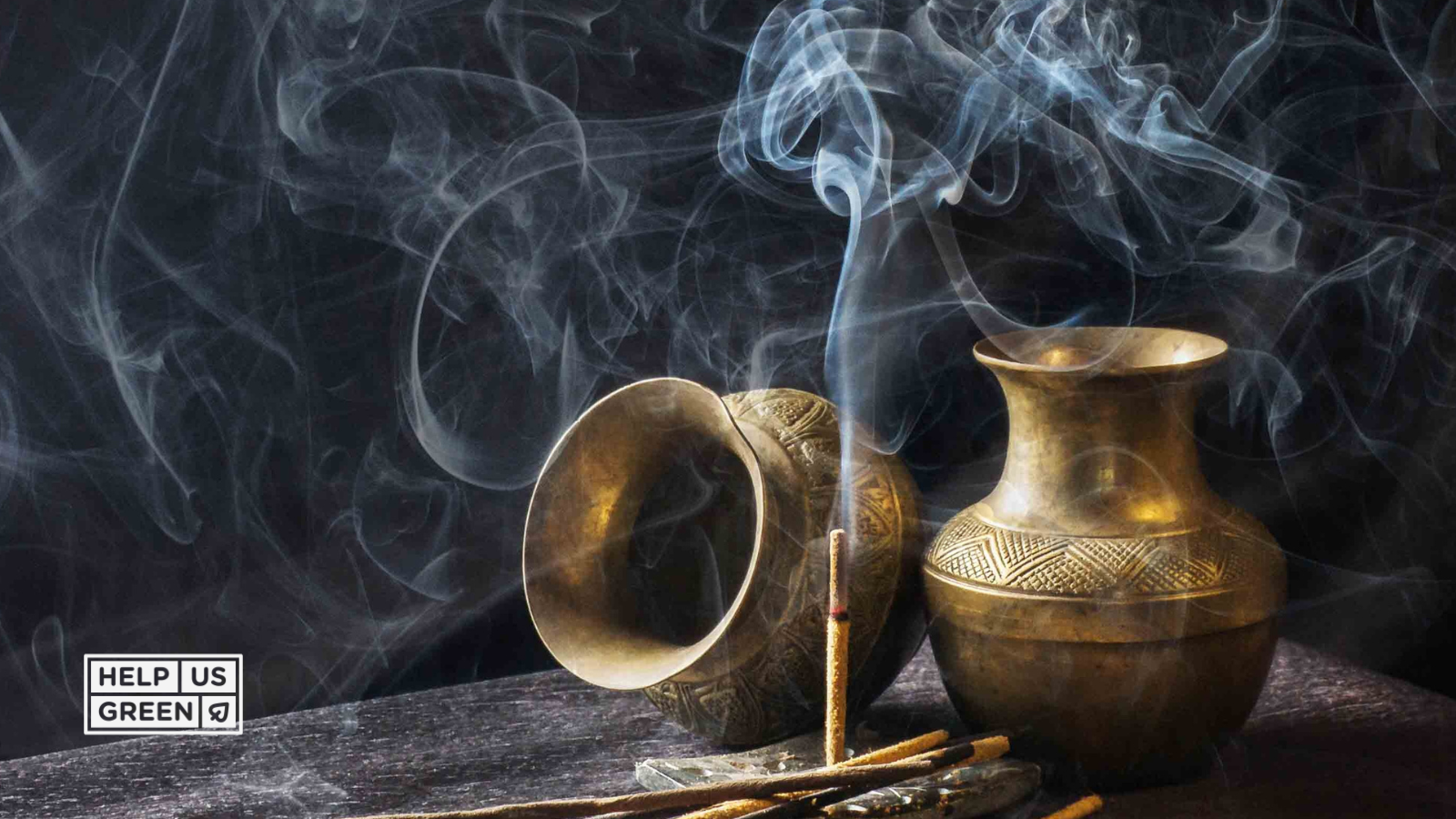 Two traditional vessels placed for a ritual, surrounded by lit incense sticks, creating a serene, sacred space for prayer or offering.
